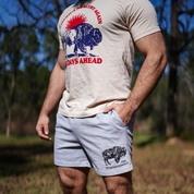 A person stands outside among trees and grass wearing the Farm Fresh Clothing Best Days Ahead MAHA Tee, a beige t-shirt featuring a bison graphic and text that celebrates regenerative agriculture.
