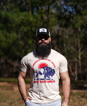 A bearded man stands outdoors among pine trees, wearing the Farm Fresh Clothing Best Days Ahead MAHA Trucker Hat and a T-shirt with a lion, child, and the words MAKE AMERICA HEALTHY AGAIN BEST DAYS AHEAD.