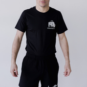A person wearing the Farm Fresh Clothing Bison Ranchers Handshake Tee in Black/White stands facing the camera with arms slightly out, against a plain light background.