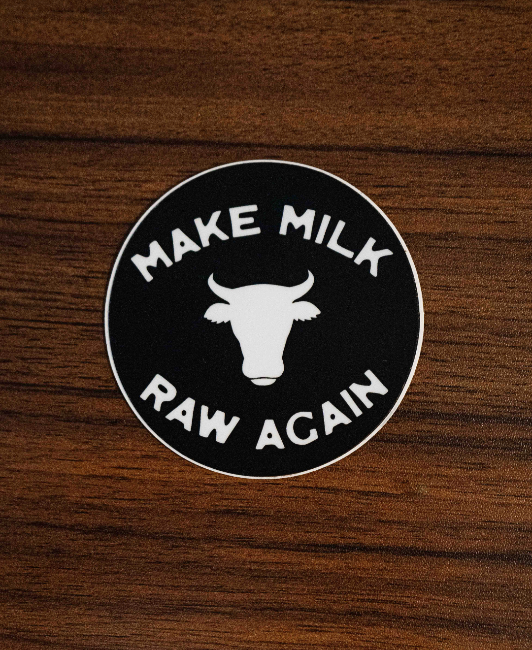 The Make Milk Raw Again Sticker by Sticker Mule is a round black vinyl sticker featuring a white cow head silhouette and bold “MAKE MILK RAW AGAIN” text, perfect for celebrating traditional dairy and dedicated farmers.