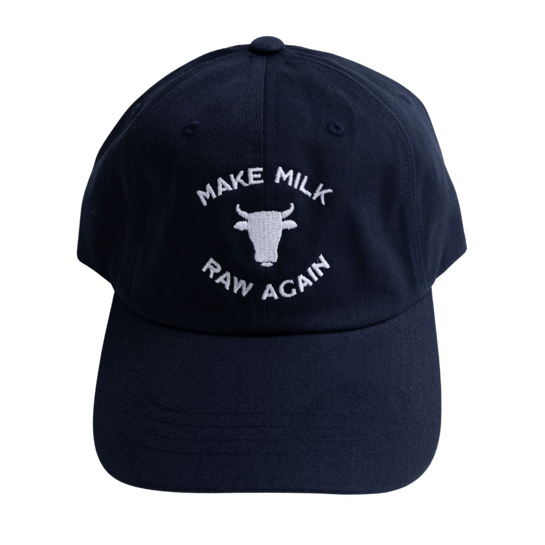 Navy cap with white text 'Make Milk Raw Again' and cow icon on a white background