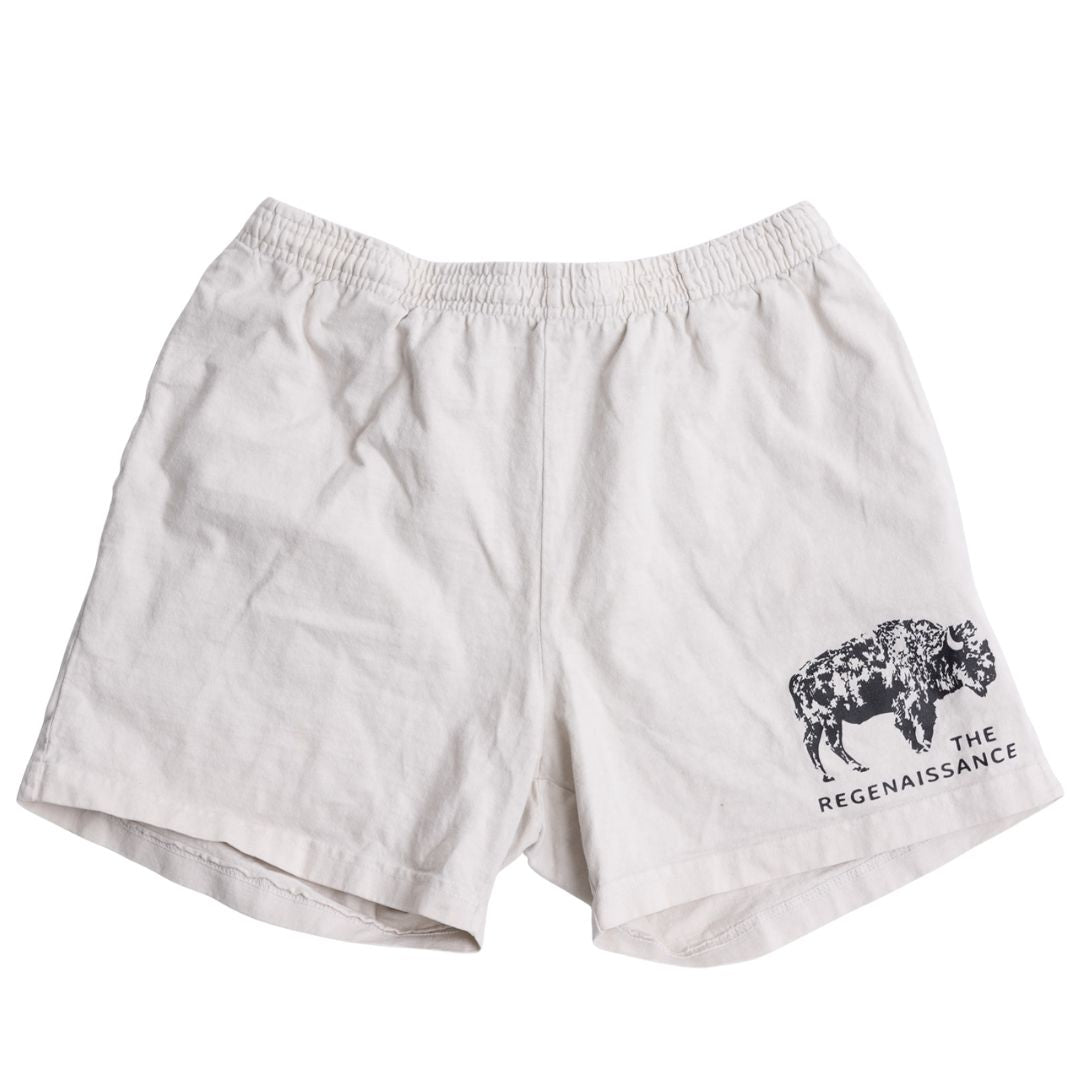 Los Angeles Apparel Men's Bison Shorts in creme feature an elastic waistband, black bison graphic, and "THE REGENAISSANCE" on the lower right leg—celebrating regenerative living and renewal.