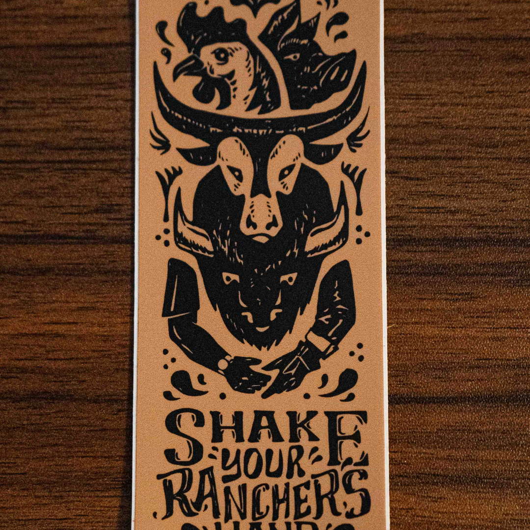 The Shake Your Ranchers Hand Sticker by Sticker Mule is a tan rectangular vinyl sticker featuring a cowboy hat with a chicken, a cow skull, and shaking hands, plus the message: SHAKE YOUR RANCHER’S HAND—know your farmer and choose real food.