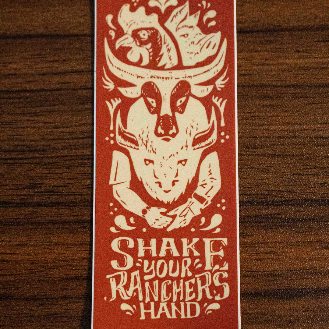 The Shake Your Ranchers Hand Sticker by Sticker Mule is a rectangular orange vinyl sticker featuring a chicken, steer skull, and hands about to shake, with SHAKE YOUR RANCHERS HAND text below in cream designs.