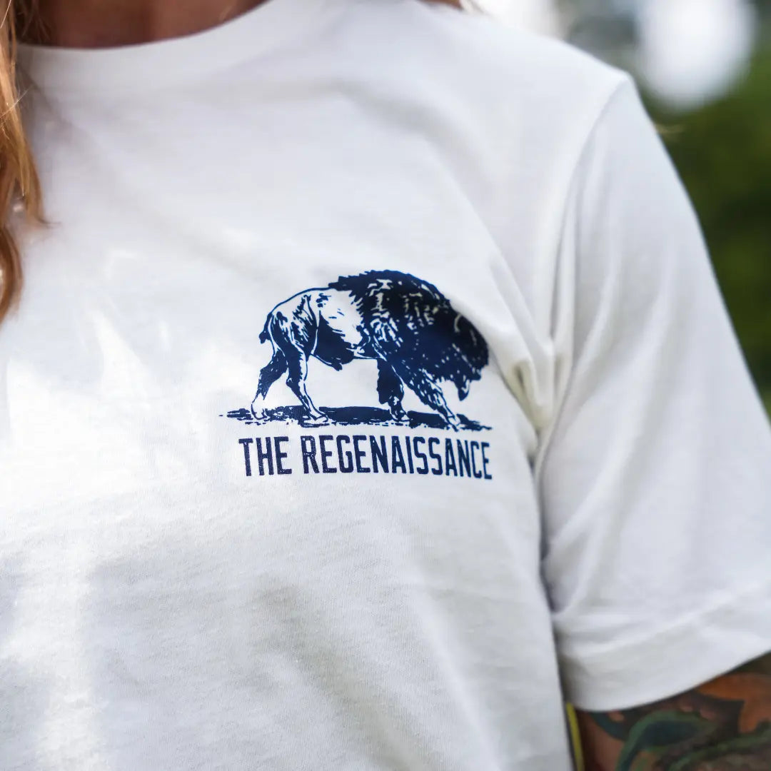 Close-up of eggshell Regenerate Agriculture Tee chest print showing navy bison graphic and The Regenaissance logo.