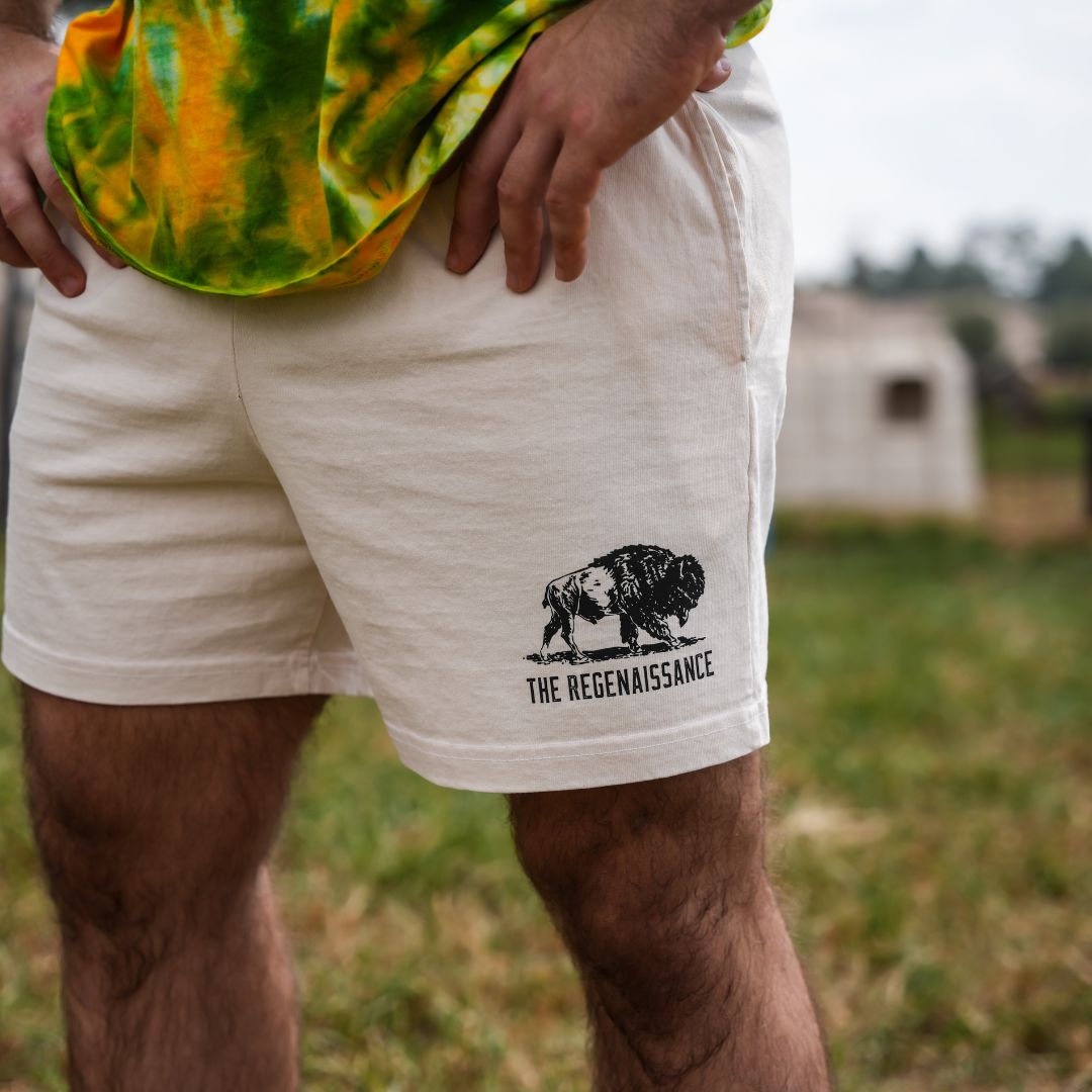 Detailed zoom of crème Regen Men’s Shorts fabric and waistband drawstring, showcasing premium material quality on a raw milk farm