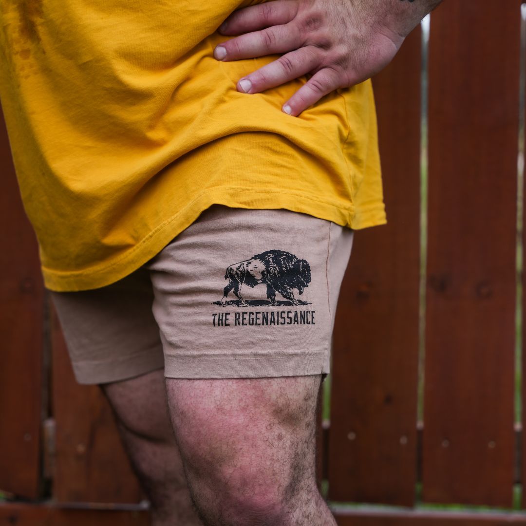 Zoomed-in detail of khaki Regen Men’s Shorts showing lightweight material, logo tag, and smooth finish.