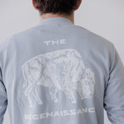 A person, shown from behind, wears the Farm Fresh Clothing Bison Crewneck Sweatshirt in light gray—an organic cotton top featuring a white bison graphic and THE REGENAISSANCE on the back, embodying sustainable values.